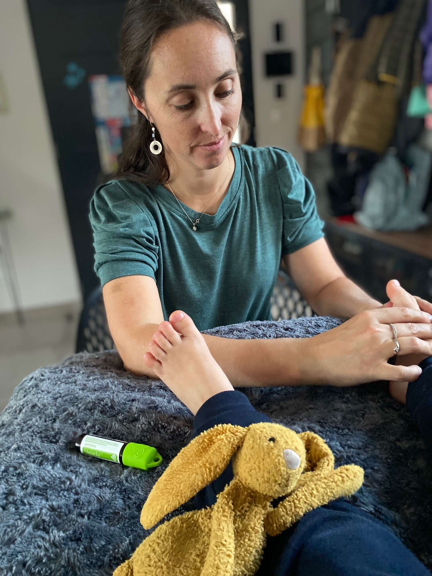 Lucie masse le pied d’un enfant, le roll-on Steady posé à côté de son doudou