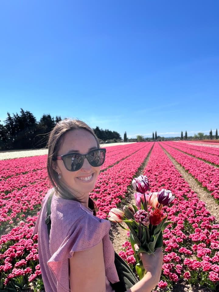 Lucie, souriante, dans un champ de tulipes