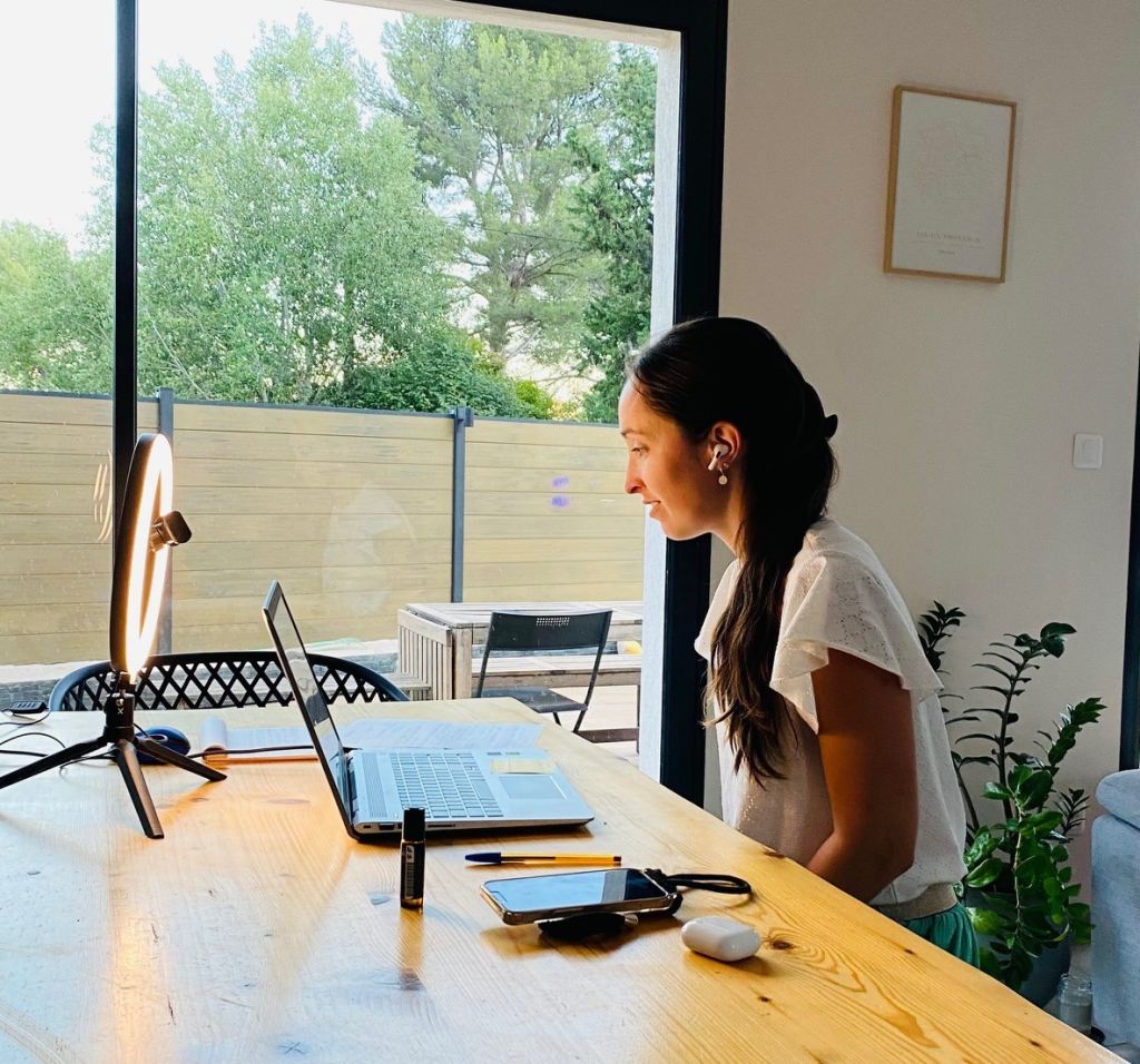 Lucie qui travaille sur une étude Feng Shui à son ordinateur, devant une baie vitrée